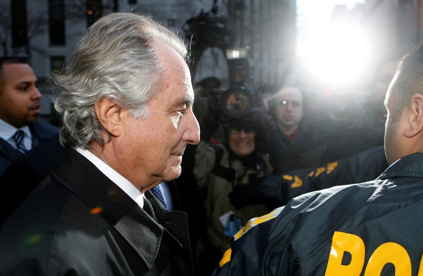 Disgraced financier Bernard Madoff is escorted by police and photographed by the media as he departs US Federal Court after a hearing in New York, January 5, 2009. (photo credit: LUCAS JACKSON/REUTERS)