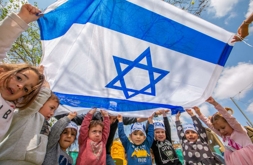 Israeli children's hold Israeli flags ahed of Israel 73rd Independence day, at a kindergarten in Moshav Yashresh, April 13, 2021.  (photo credit: YOSSI ALONI/FLASH90)