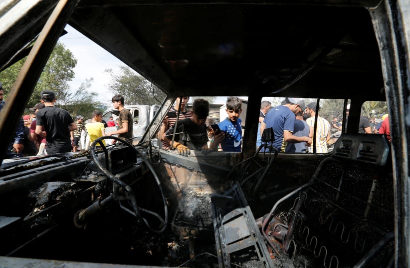 People inspect the site of a car bomb attack in Sadr City district of Baghdad, Iraq April 15, 2021. (photo credit: WISSAM AL-OKAILI/REUTERS)