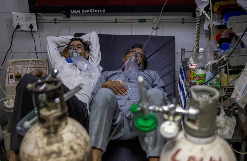 Patients suffering from the coronavirus disease (COVID-19) get treatment at the casualty ward in Lok Nayak Jai Prakash (LNJP) hospital, amidst the spread of the disease in New Delhi, India April 15, 2021.  (photo credit: REUTERS/DANISH SIDDIQUI)