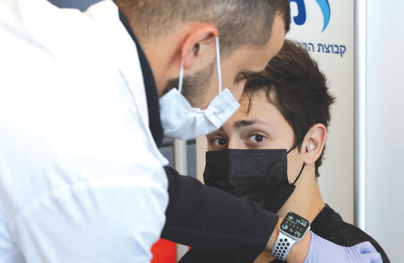 A TEENAGER receives a vaccination against COVID-19 in Tel Aviv, earlier this year. (photo credit: RONEN ZVULUN/REUTERS)
