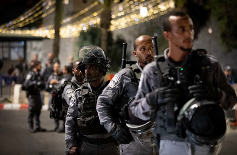 Police Officers stand guard during clashes between Palestians and Israeli police outside Damascus Gate in Jerusalem on April 18, 2021. Clashes erupted after Israeli police put barriers that prevented people from sitting on the steps in the plaza outside the gate.  (photo credit: YONATAN SINDEL/FLASH 90)