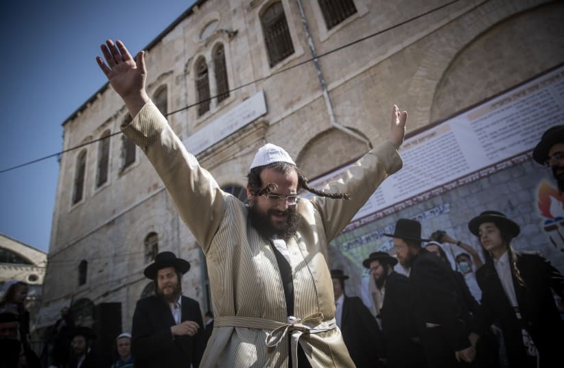 Ultra orthodox jewish men dance during celebrations of the Jewish holiday of Lag Baomer in the ultra-orthodox neighborhood of Mea Shearim in Jerusalem on May 12, 2020.  (photo credit: YONATAN SINDEL/FLASH 90)