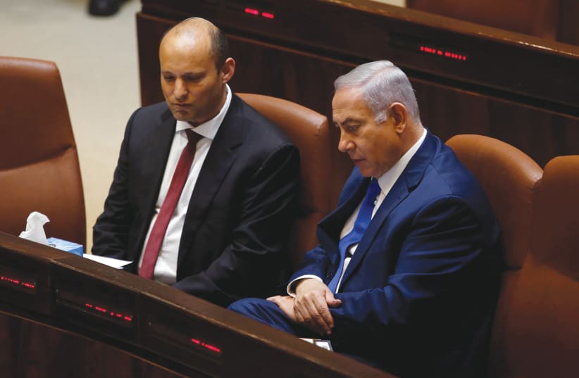 Prime Minister Benjamin Netanyahu chats with Naftali Bennett in the Knesset (photo credit: RONEN ZVULUN/REUTERS)