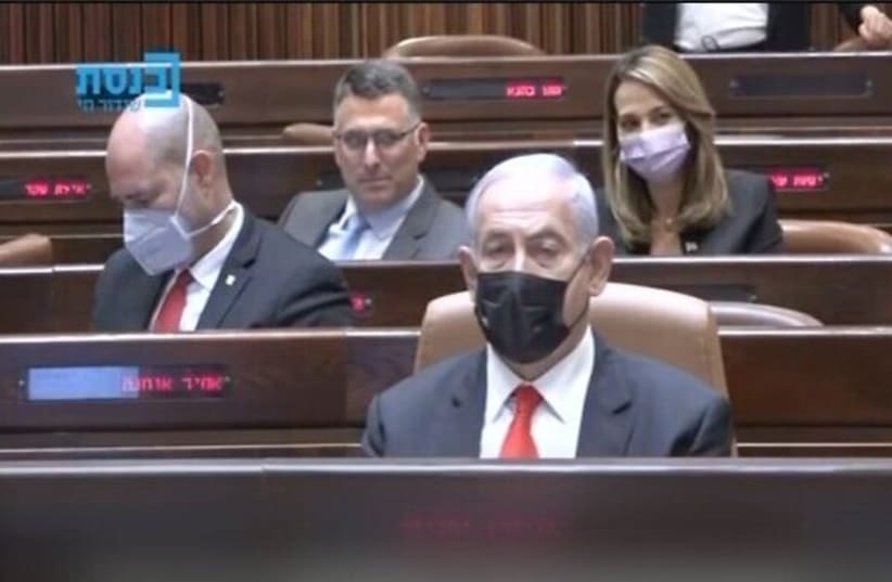 A screenshot shows New Hope leader Gideon Sa'ar winking behind Prime Minister Benjamin Netanyahu in the Knesset on April 19, 2021. (photo credit: SCREENSHOT/KNESSET CHANNEL)