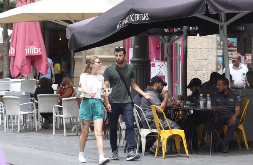 Israelis in Jerusalem are seen without face masks after coronavirus restrictions were eased. (photo credit: MARC ISRAEL SELLEM/THE JERUSALEM POST)