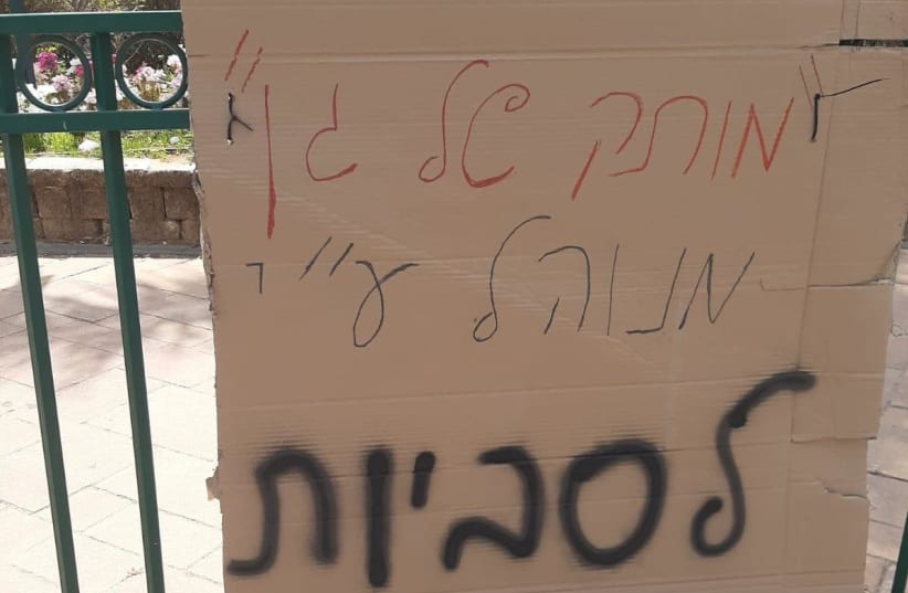 A sign which says "[this kindergarten] is run by lesbians" was hung on a short railing near Moatza square in Be'er Ya'acov, April 21, 2021. (photo credit: THE AGUDAH - ISRAEL'S LGBT TASK FORCE)