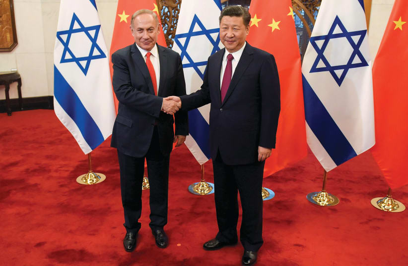 CHINESE PRESIDENT Xi Jinping and Prime Minister Benjamin Netanyahu shake hands in Beijing in 2017. Navon’s book addresses Israel’s complex relations in Asia and elsewhere (photo credit: ETIENNE OLIVEAU/POOL/REUTERS)