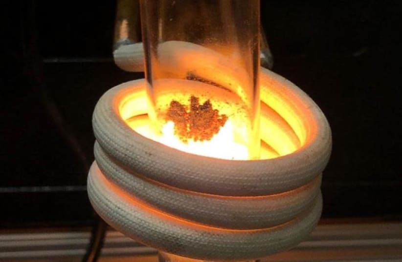 A simulation of HELIOS' induction furnace shows sand from the moon burning at 1,600 degree's Celsius.  (photo credit: CHAYA GOLD)