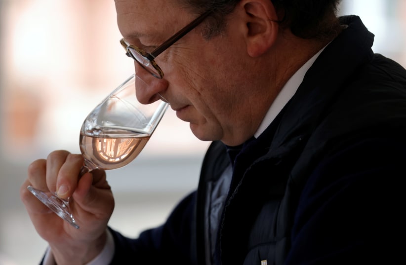 A man is seen smelling champagne at a wine tasting session in France on April 14, 2021. (photo credit: PASCAL ROSSIGNOL/REUTERS)