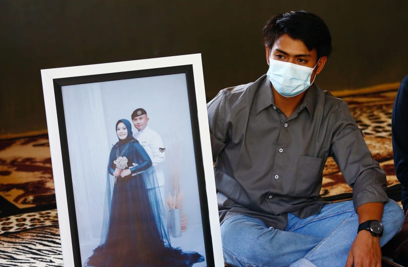 Imam Yoga, 26-year-old brother-in-law of Pandu Yudha Kusuma, 23, one of the crew members of the sunken KRI Nanggala-402 submarine, shows a photograph during an interview at his parents' house in Banyuwangi (photo credit: REUTERS)