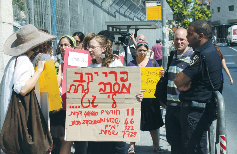 A WOMAN (foreground) holds a sign that says her husband has refused to give her a ‘get’ (writ of divorce) for nearly a year, at a protest outside the Justice Ministry in Jerusalem in 2011. (photo credit: YOSSI ZAMIR/FLASH90)