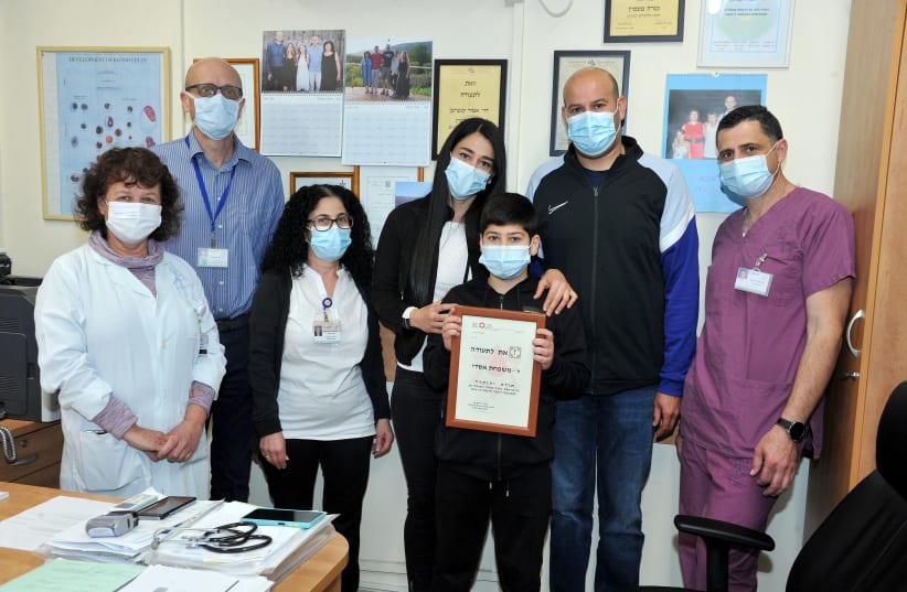 Members of the Assadi family with the certificate of appreciation and representatives of the medical center.  (photo credit: RONI ALBERT)