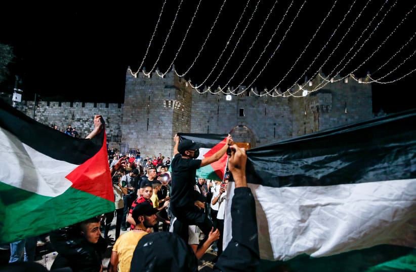 Arabs wave Palestinians flags at Damascus Gate in Jerusalem's Old City, during the holy Muslim month of Ramadan, April 25, 2021.  (photo credit: JAMAL AWAD/FLASH90)