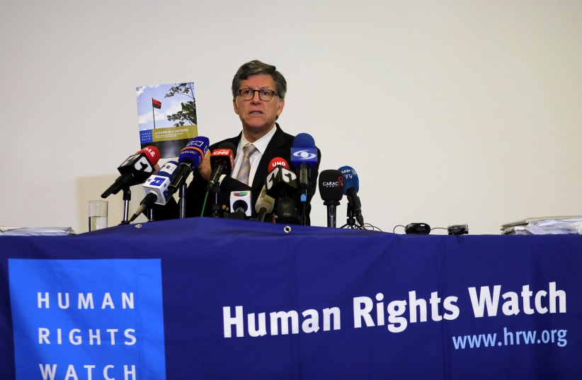 Jose Miguel Vivanco, director of Human Rights Watch Americas, holds up a report while addressing the media in Bogota (photo credit: REUTERS)