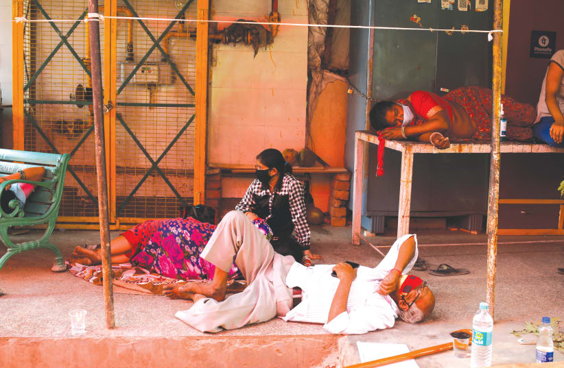 PEOPLE STRUGGLING with COVID-19 wait to receive oxygen at a Sikh temple in Ghaziabad, India, on Tuesday. (photo credit: ADNAN ABIDI/ REUTERS)