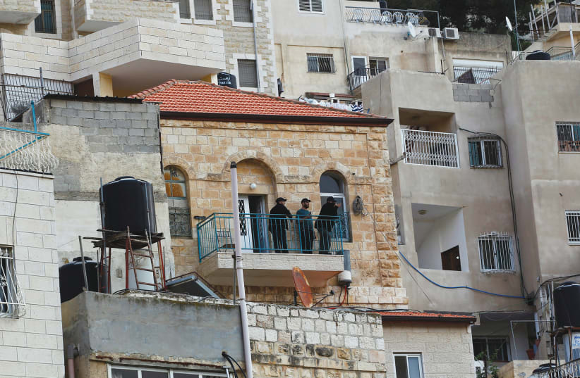 GUARDS STAND on the balcony of a house purchased by Jews in the mostly Arab east Jerusalem neighborhood of Silwan in 2014. (photo credit: RONEN ZVULUN/REUTERS)