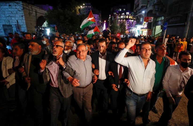 Palestinians take part in a rally demanding President Mahmoud Abbas to hold elections on planned time, in Ramallah in the Israeli-occupied West Bank April 29, 2021 (photo credit: REUTERS/MOHAMAD TOROKMAN)