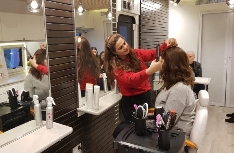 A woman getting her hair cut for donation in the "Braid of Strength" campaign (photo credit: ZICHRON MENACHEM PR)