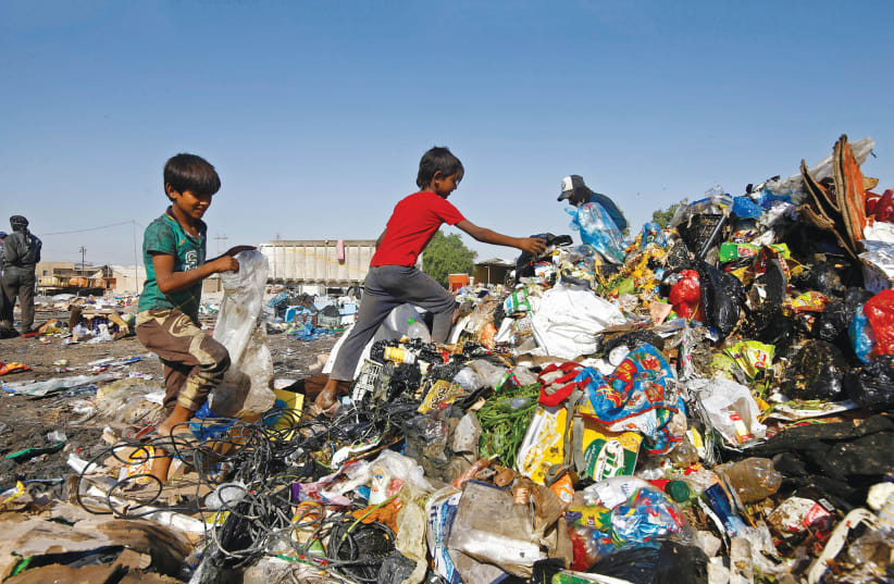 CHILDREN COLLECT recyclable garbage at a dump in Najaf, Iraq, last year. (photo credit: ALAA AL-MARJANI/REUTERS)