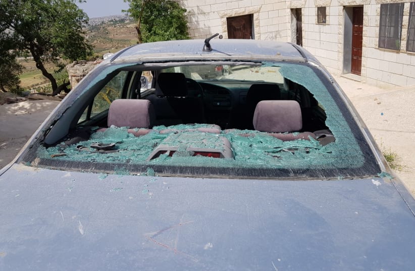 A car is seen smashed by stones in the Palestinian village of Jalud in the West Bank. (photo credit: YESH DIN)