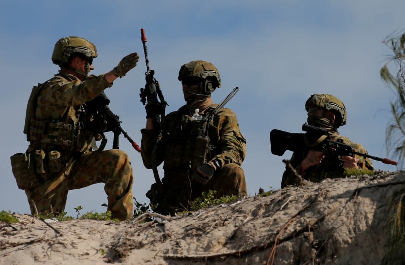 Soldiers from the Australian Army's 3rd Brigade guard Langham Beach after an amphibious assault landing during the Talisman Saber joint military exercises between Australia and the United States in Queensland, northeast Australia, July 13, 2017 (photo credit: REUTERS/JASON REED)