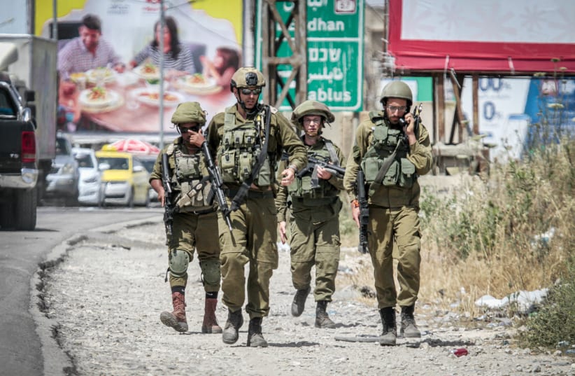 Israeli soldiers guard at the Hawara checkpoint, outside the West Bank city of Nablus, May 4, 2021 (photo credit: NASSER ISHTAYEH/FLASH90)