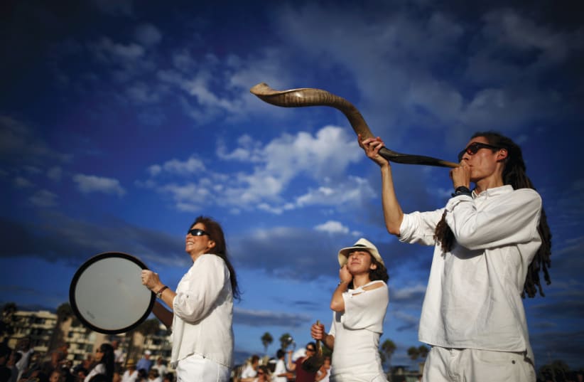 ARED STEIN blows a shofar as Rabbi Naomi Levy plays a drum at the Nashuva Spiritual Community Jewish New Year celebration in LA, 2015 (photo credit: LUCY NICHOLSON / REUTERS)