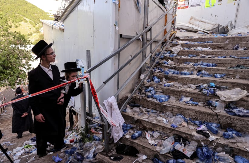Ultra-Orthodox Jews look at stairs with waste on it in Mount Meron, northern Israel, where fatalities were reported among the thousands of ultra-Orthodox Jews gathered at the tomb of a 2nd-century sage for annual commemorations that include all-night prayer and dance, April 30, 2021. (photo credit: RONEN ZVULUN/REUTERS)