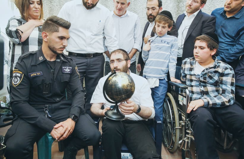 Rabbi Avigdor HAYUT and his son Shmuel meet the Bedouin police officer, Rami Alwan, who helped save them at Mount Meron. The family was sitting shiva for Yedidyia, 13, who died in the disaster. (photo credit: FLASH90)