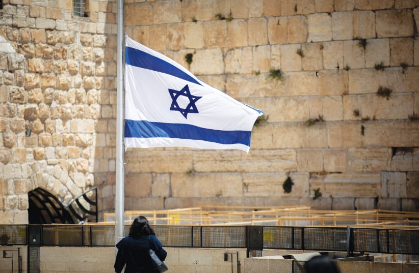 A FLAG at the Western Wall is lowered to half-mast as a mark of mourning for the Mount Meron victims, earlier this week.  (photo credit: YONATAN SINDEL/FLASH90)