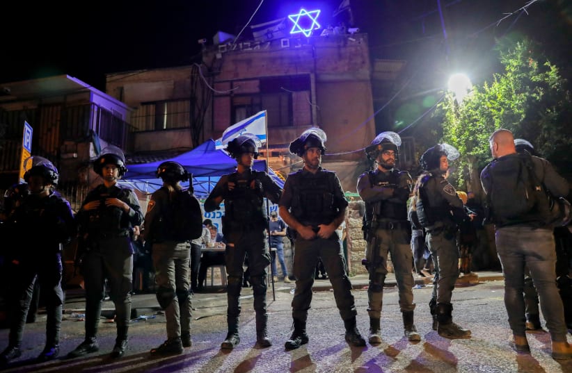 Israeli security forces clash with protesters outside a home of a Jewish family during a protest against Israel's plan to demolish some houses of Palestinians in the East Jerusalem neighborhood of Sheikh Jarrah on May 6, 2021.  (photo credit: OLIVIER FITOUSSI/FLASH90)