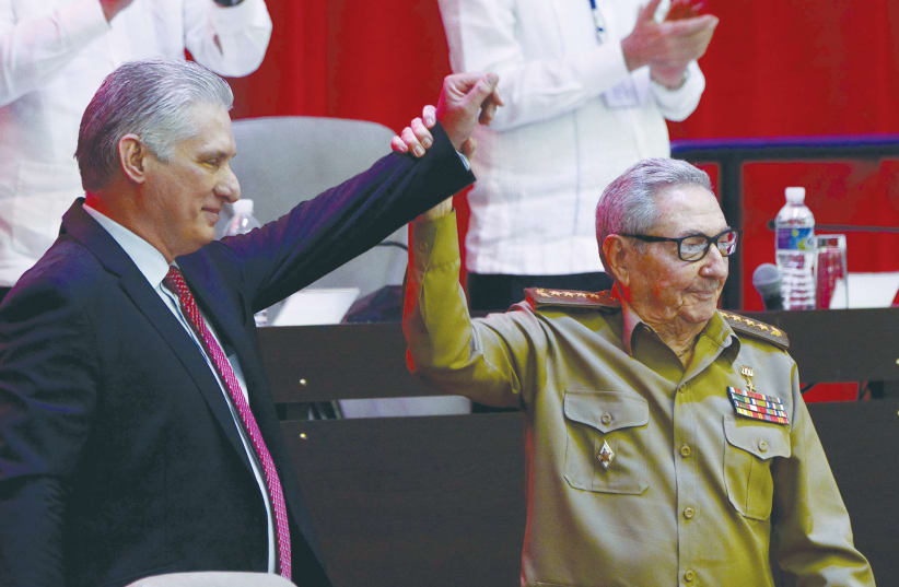 CUBAN PRESIDENT and Communist Party First Secretary Miguel Díaz-Canel joins hands with Raúl Castro during the closing session of the Congress of the Communist Party in Havana last month.  (photo credit: ARIEL LEY ROYERO/ACN VIA REUTERS)