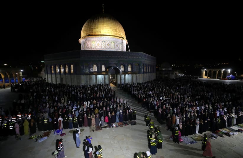 Palestinians pray in front of the Dome of the Rock on Laylat al-Qadr during the holy month of Ramadan, at the compound that houses Al-Aqsa Mosque, known to Muslims as Noble Sanctuary and to Jews as Temple Mount, in Jerusalem's Old City, May 8, 2021. (photo credit: AMMAR AWAD/REUTERS)