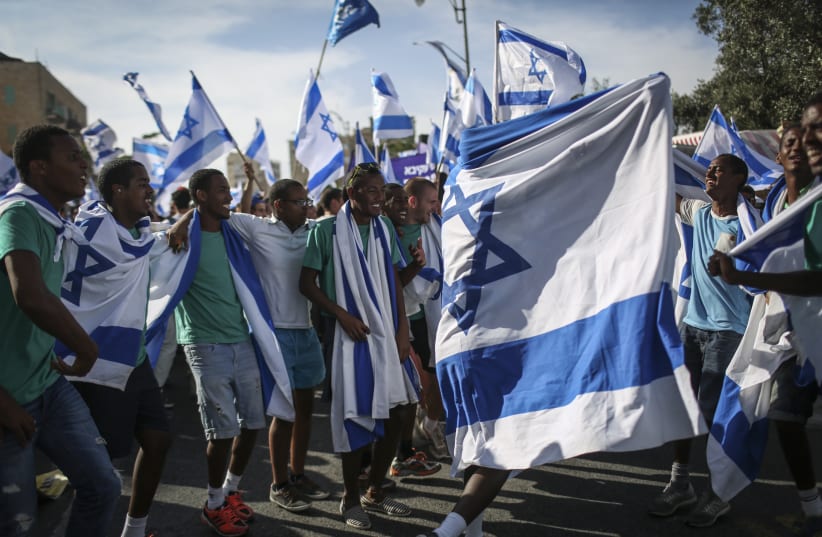 Groups of Jewish youth movements wave Israeli flags as they celebrate Jerusalem Day by the Great Synagogue, on King George Street, before taking part in the parade to the Old City. Jerusalem Day celebrates the 47th anniversary of its capture of Arab East Jerusalem in the Six Day War of 1967.  (photo credit: HADAS PARUSH/FLASH90)
