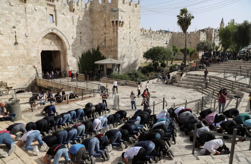 Palestinians pray amid Israeli-Palestinian tension as Israel marks Jerusalem Day, at Damascus Gate just outside Jerusalem's Old City May 10, 2021. (photo credit: RONEN ZVULUN/REUTERS)