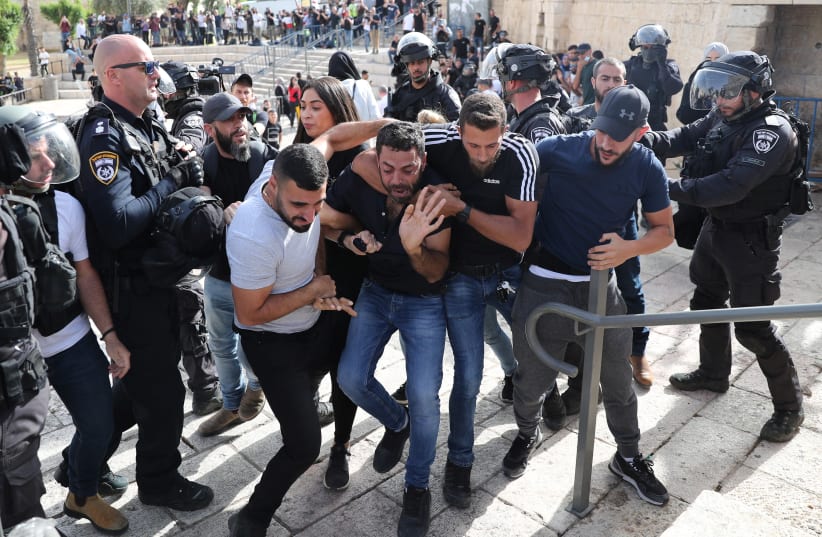 A Palestinian man reacts as he is detained by undercover Israeli security force members amid Israeli-Palestinian tension as Israel marks Jerusalem Day, near Damascus Gate just outside Jerusalem's Old City May 10, 2021. (photo credit: RONEN ZVULUN/REUTERS)