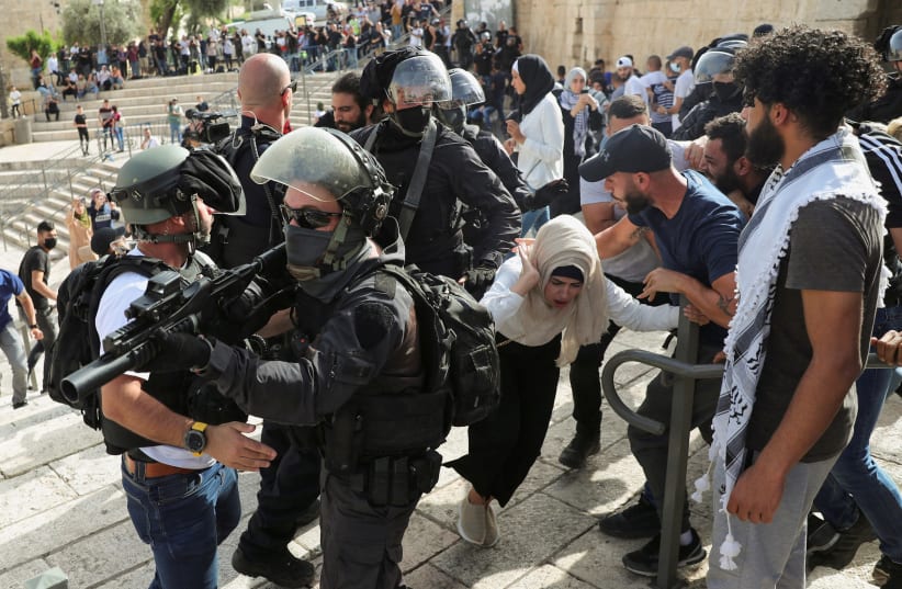 A Palestinian woman reacts during scuffles with Israeli security force members amid Israeli-Palestinian tension as Israel marks Jerusalem Day, near Damascus Gate just outside Jerusalem's Old City May 10, 2021. (photo credit: RONEN ZVULUN/REUTERS)
