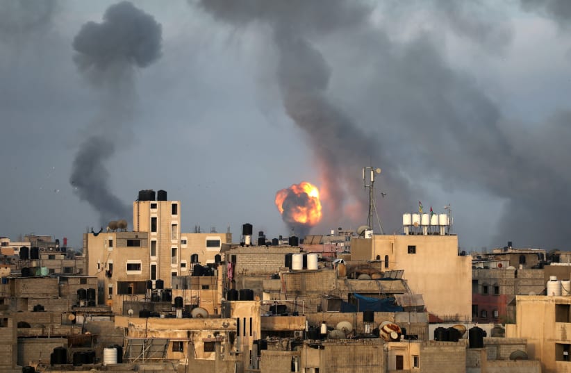 Flames and smoke rise during Israeli air strikes amid a flare-up of Israel-Palestinian violence, in the southern Gaza Strip May 11, 2021 (photo credit: IBRAHEEM ABU MUSTAFA / REUTERS)