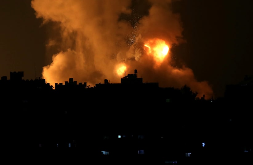 Flames rise following an Israeli air strike amid a flare-up of Israel-Palestinian violence, in the southern Gaza Strip May 10, 2021 (photo credit: IBRAHEEM ABU MUSTAFA / REUTERS)