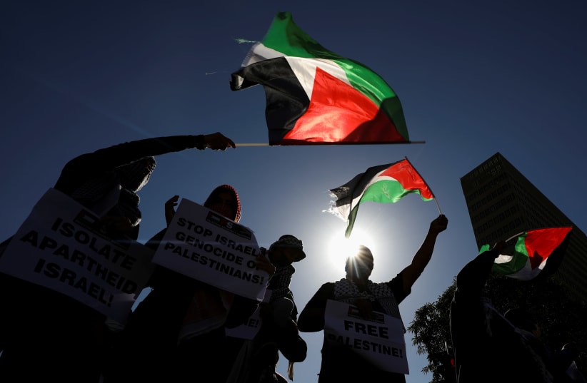 South African demonstrators wave Palestinian flags during a protest following clashes between Palestinians and Israeli police at Al Asqa Mosque in Jerusalem, outside parliament in Cape Town, South Africa, May 11, 2021. (photo credit: MIKE HUTCHINGS / REUTERS)
