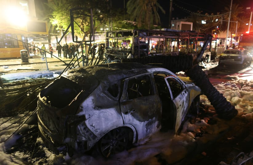Burnt vehicles are seen at the scene where a rocket launched from the Gaza Strip hit, in Holon, Israel May 11, 2021. (photo credit: RONEN ZVULUN/REUTERS)