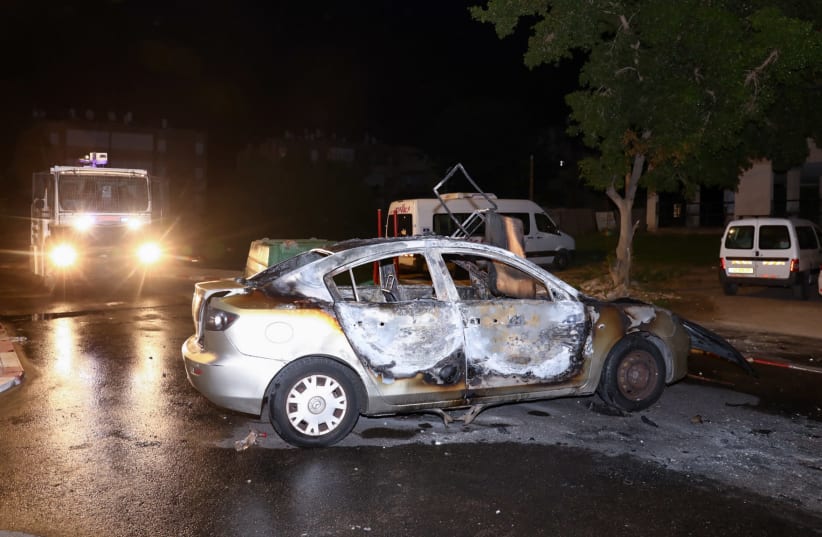 A car set on fire by Israeli Arab residents during riots and clashes between Arab and Jewish residents, in the central Israeli town of Lod, on May 12, 2021.  (photo credit: YOSSI ALONI/FLASH90)