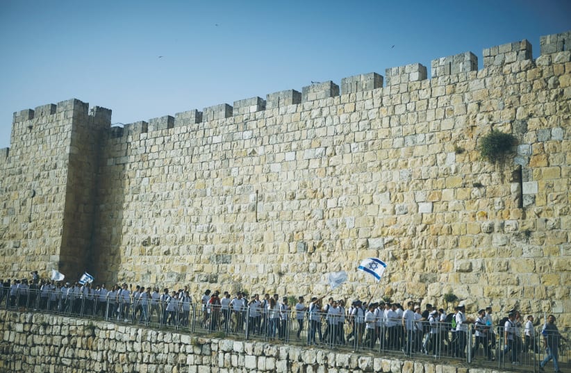 YOUTHS WAVE Israeli flags during the Jerusalem Day march around the Old City walls on Monday.  (photo credit: NIR ELIAS / REUTERS)