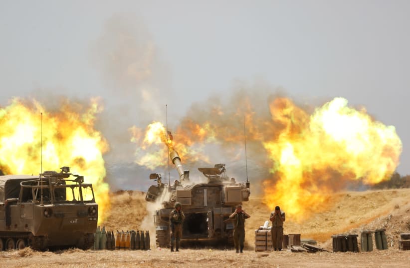 IDF Artillery Corps are seen firing into Gaza following heavy rocket and missile barrages fired into Israel from the Strip, on May 12, 2021. (photo credit: YONATAN SINDEL/FLASH90)