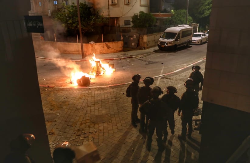 Police seen on the streets of the central Israeli city of Lod, where last night synagogues and cars were torched as well as shops damaged, by Arab residents, May 12, 2021 (photo credit: YOSSI ALONI/FLASH90)