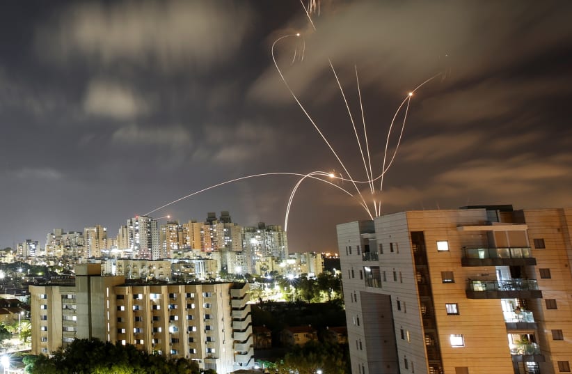 Streaks of light are seen as Israel's Iron Dome anti-missile system intercepts rockets launched from the Gaza Strip towards Israel, as seen from Ashkelon, Israel May 12, 2021.  (photo credit: AMIR COHEN/REUTERS)