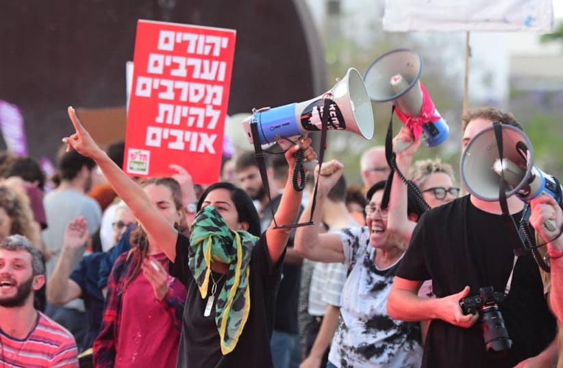 Jewish and Arab Israelis are seen holding a pro-coexistence rally in Tel Aviv, on May 13, 2021. (photo credit: AVSHALOM SASSONI/MAARIV)