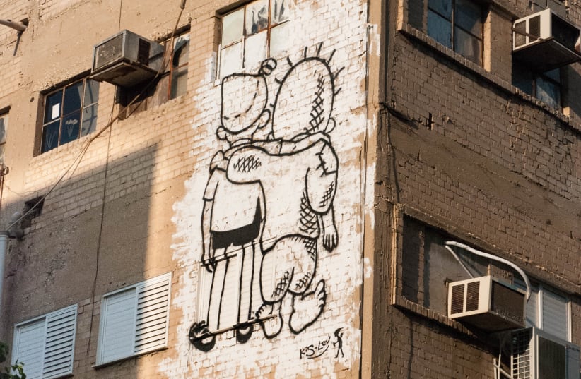 “The Peace Kids” mural in Tel Aviv, which depicts iconic Israeli and Palestinian cartoon characters embracing one another, was created with the cooperation of Israeli and Palestinian artists, May 2015. (photo credit: Wikimedia Commons)