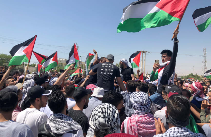 Demonstrators hold Palestinian flags during a protest to express solidarity with the Palestinian people,in Karameh, Jordan valley, May 14th, 2021. (photo credit: REUTERS/JEHAD SHELBAK)
